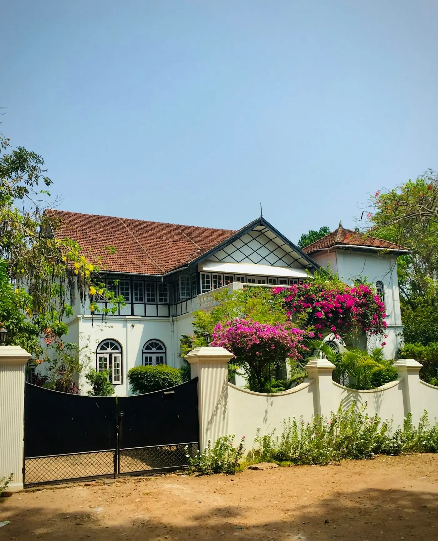 A whitewashed colonial-era house behind an iron gate in Fort Kochi