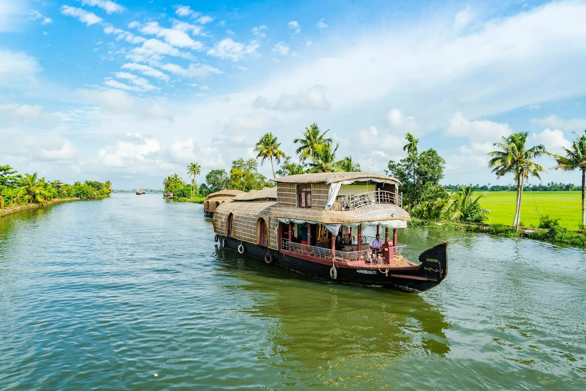 A traditional kettuvallam houseboat on the palm-lined backwaters of Alappuzha