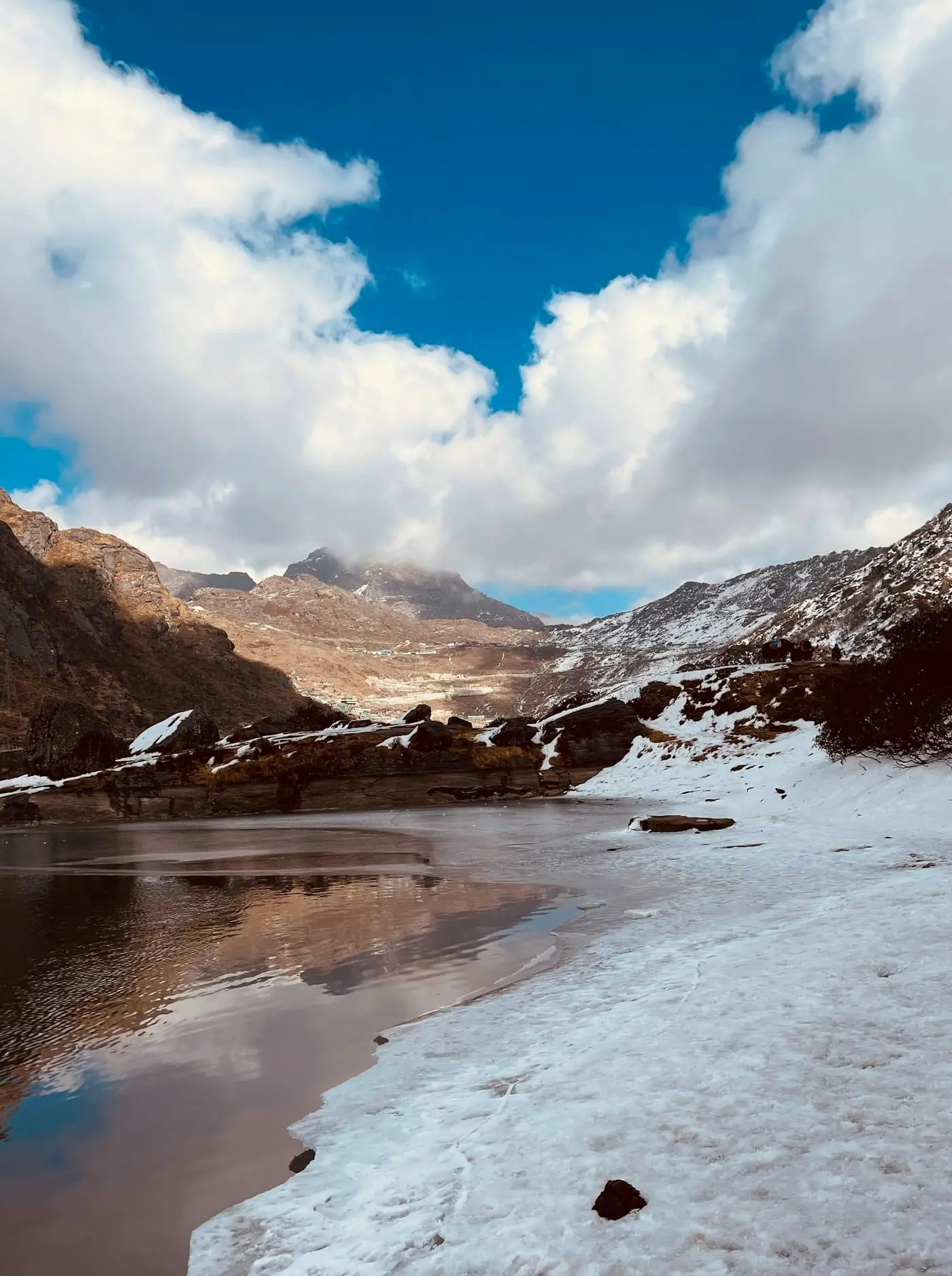 Cloud drifting over Tsomgo Lake and its snowy ridges